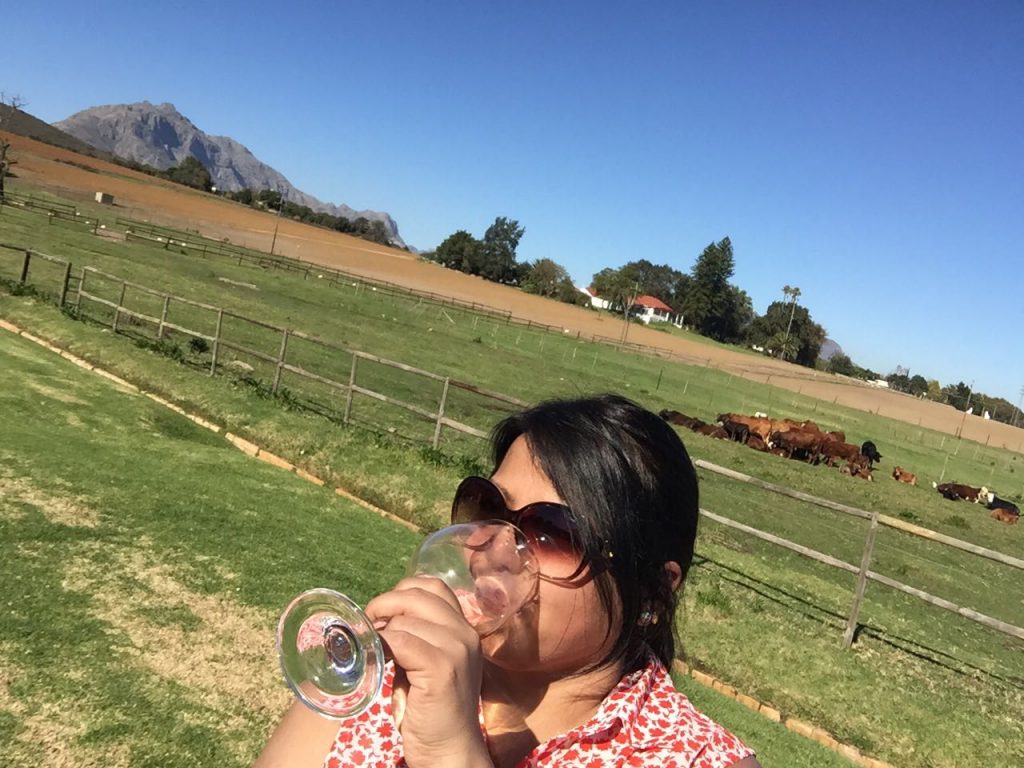 Nishma enjoying a glass of wine in the Winelands, South Africa