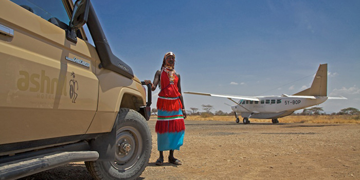 Masai warrior beside a Somak safari vehicle