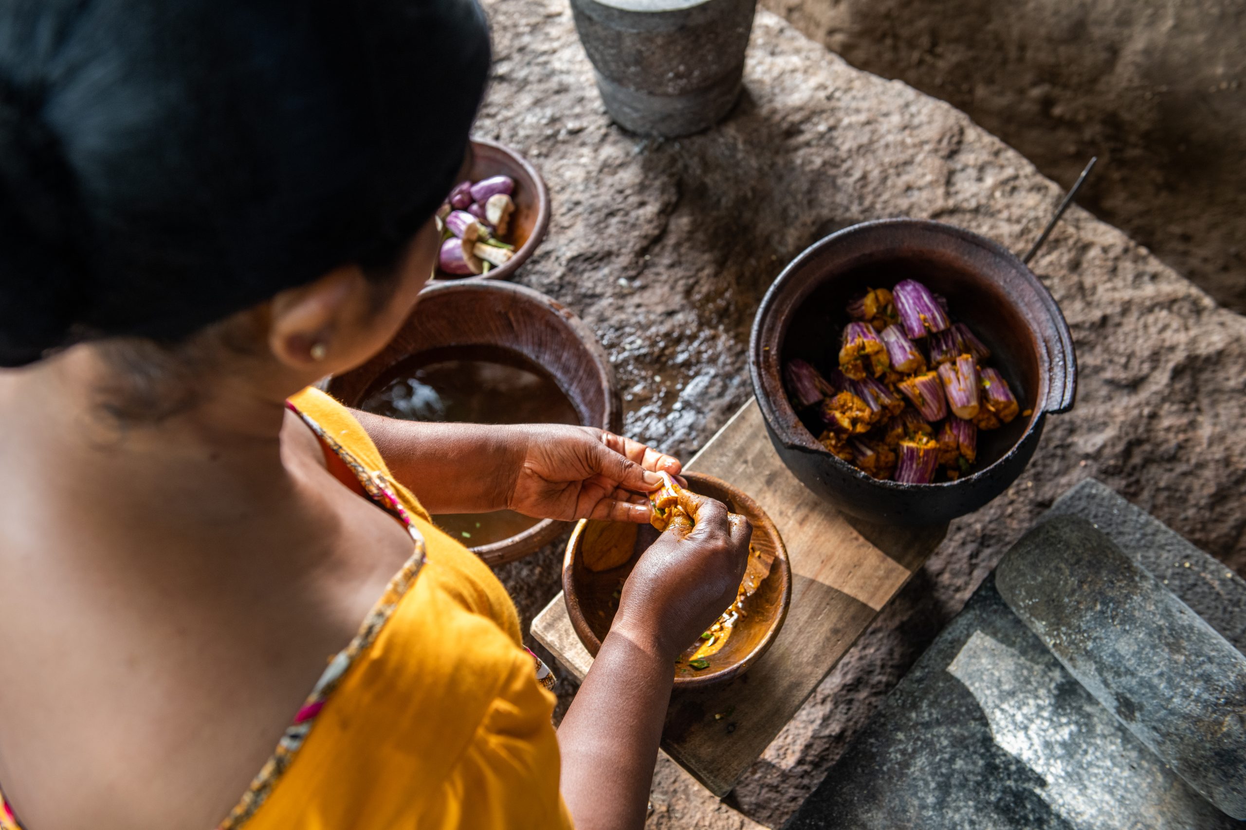 Woman preparing food for the Kamatha experience in a rural setting